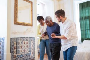 Health care workers offering home health care services to a senior citizen.